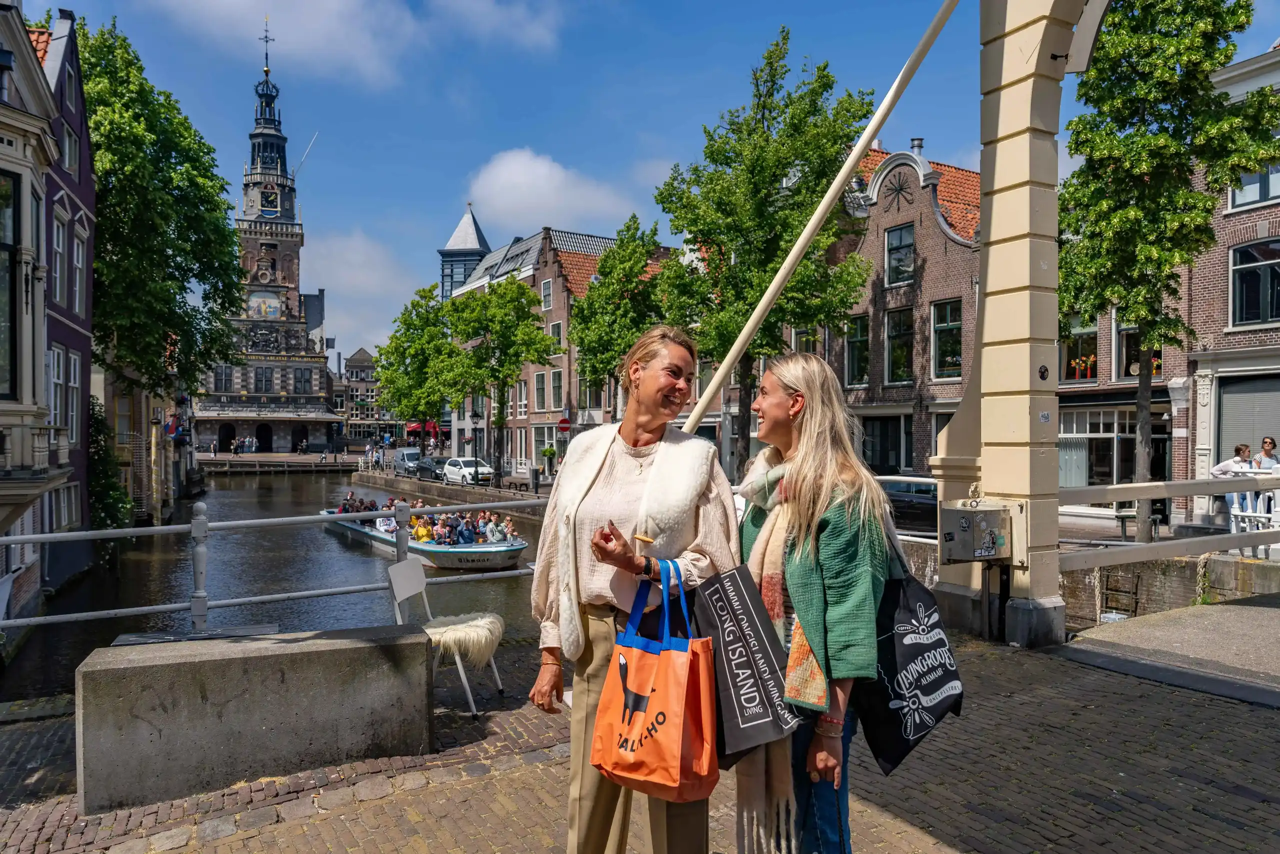 Moeder en dochter lopend met rondvaart boot en waagtoren